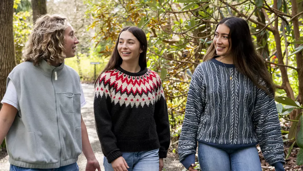Three students walking through UVic's Finnerty Gardens.