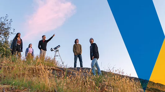 group of students on a hill with a telescope