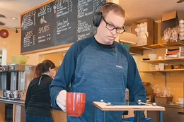 Coco Cafe barista, Colin, using the assistive technology built for him by CanAssist.
