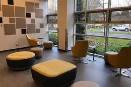 Room with yellow and orange chairs facing a window
