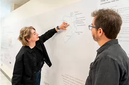 Two people looking at a wall map