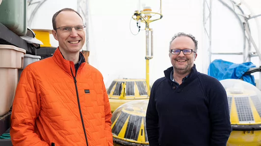 Curran Crawford and Brad Buckham stand with scientific equipment.