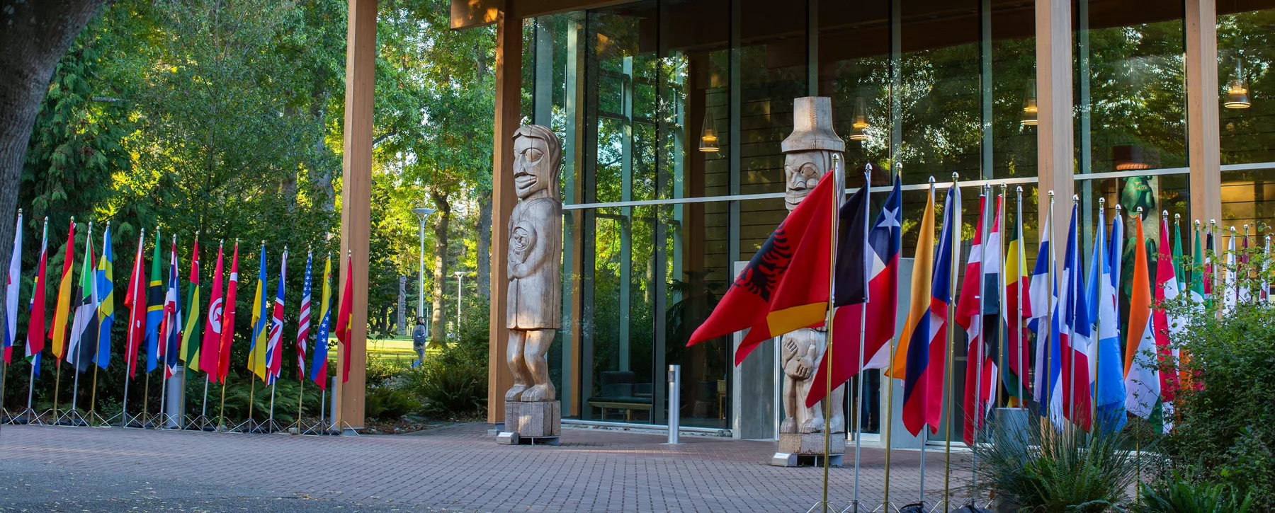 Photo of the exterior of UVic´s First People´s House with a set of flags from different countries f