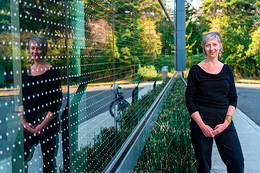 UVic geographer and civil engineer Christina Hoicka stands beside a solar panel.