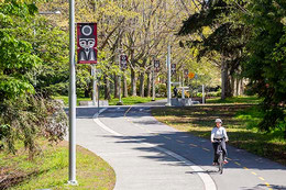 Woman rides bike on campus greenway