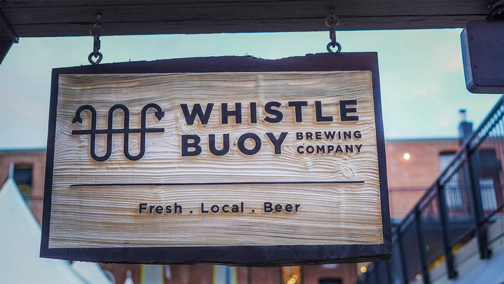 Wooden sign that says "Whistle Buoy Brewing Company... Fresh. Local. Beer"