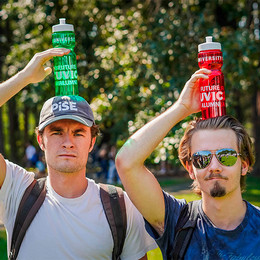 Two people holding water bottles that say Future UVic Alumni on their heads. 