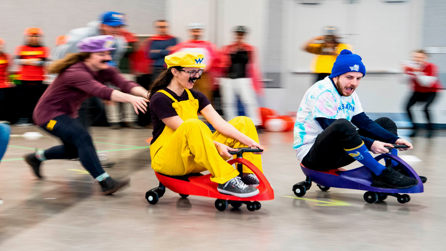 Two people racing on plasma cars for United Way