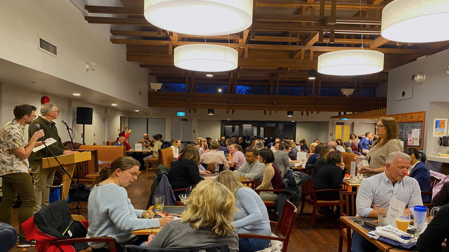 Room full of people sitting at tables participating in a pub quiz