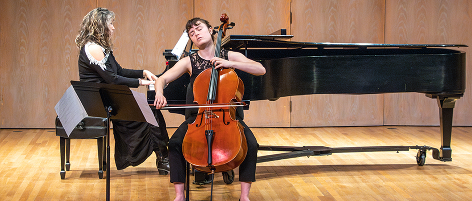 Female student playing a cello on stage