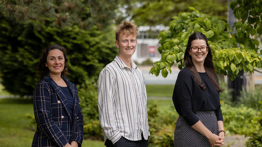 Tiny Summit 2024 participants Sahar Sam, Matt Sutherland and Michela Palmer pose outdoors for a group photo outdoors