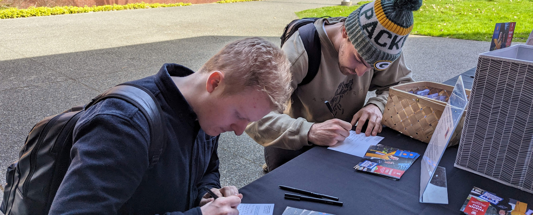 Two students sign thank you cards for donors