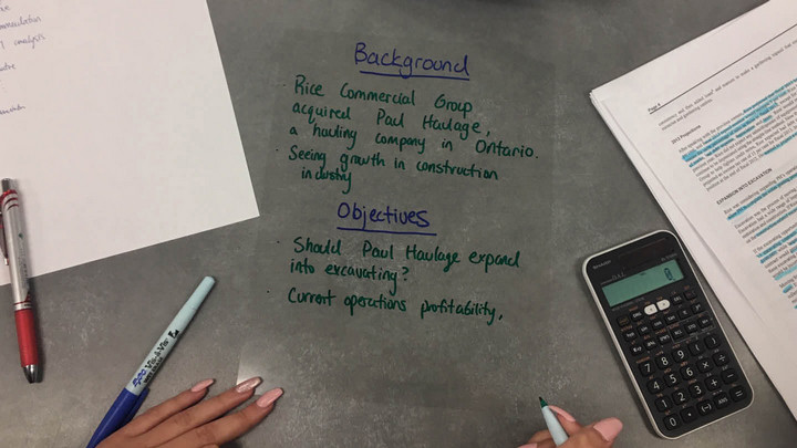 The team writes out their plan on slides to be presented on an overhead projector