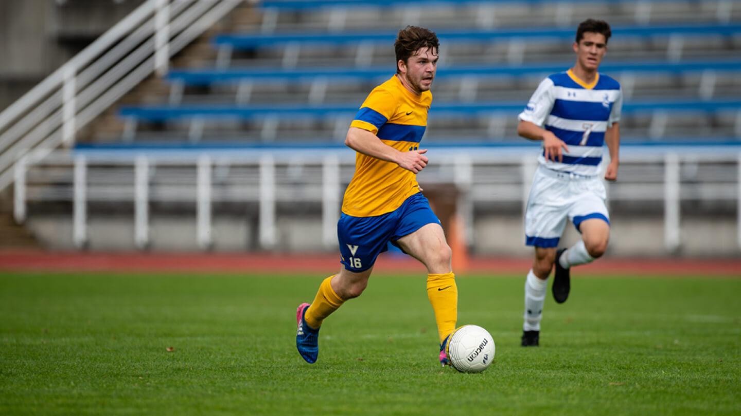 Will Adams running with a soccer ball for the UVic Vikes soccer team