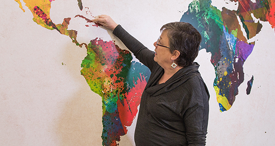 Michèle Favarger pointing at Cuba on a wall map