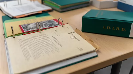 Binders of archival materials on a reading room table