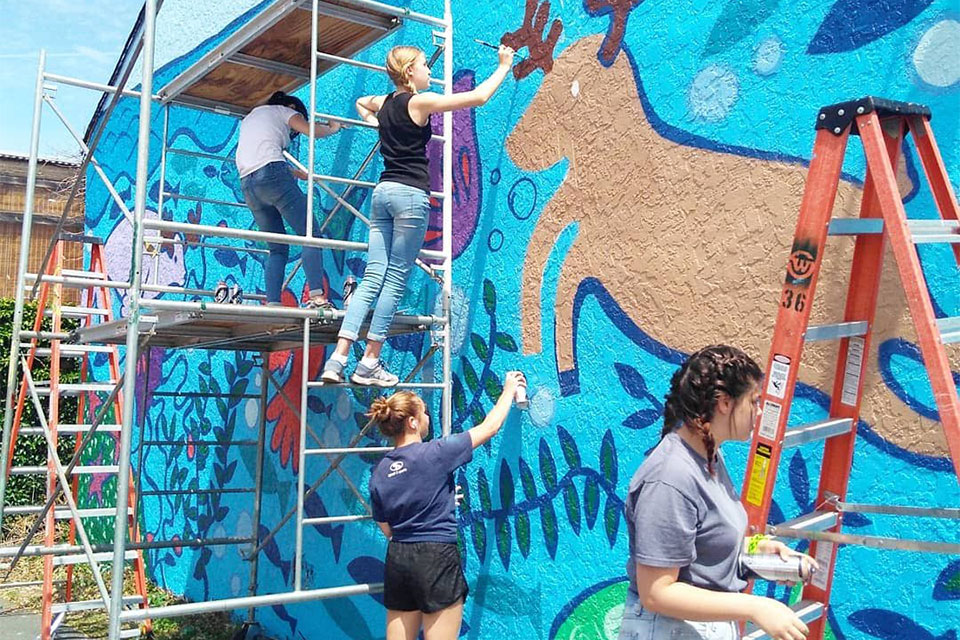 Students painting a mural outside