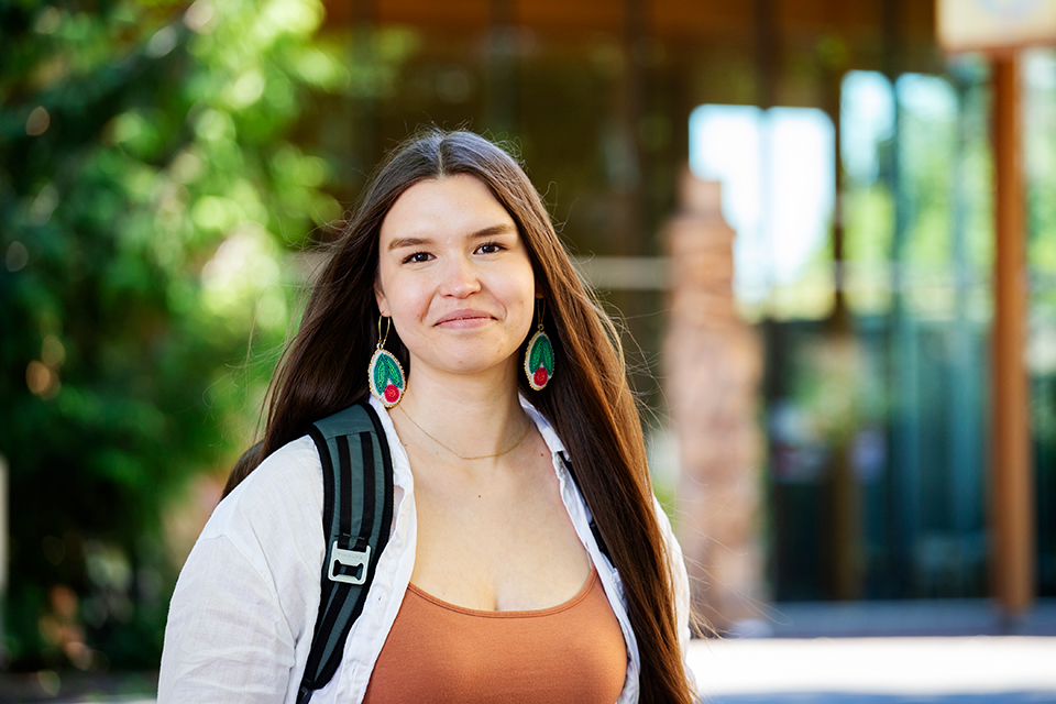 K’sana Wood Lynes-Ford stands in front of the First Peoples House. 