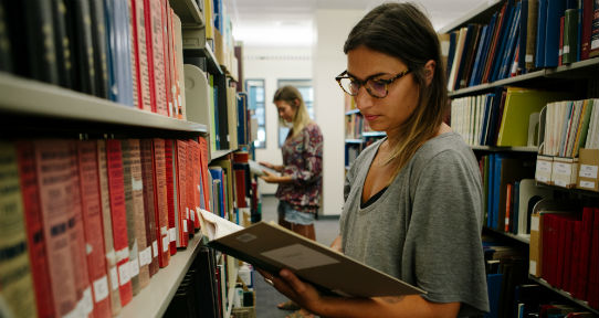 Student reading a book in the library 