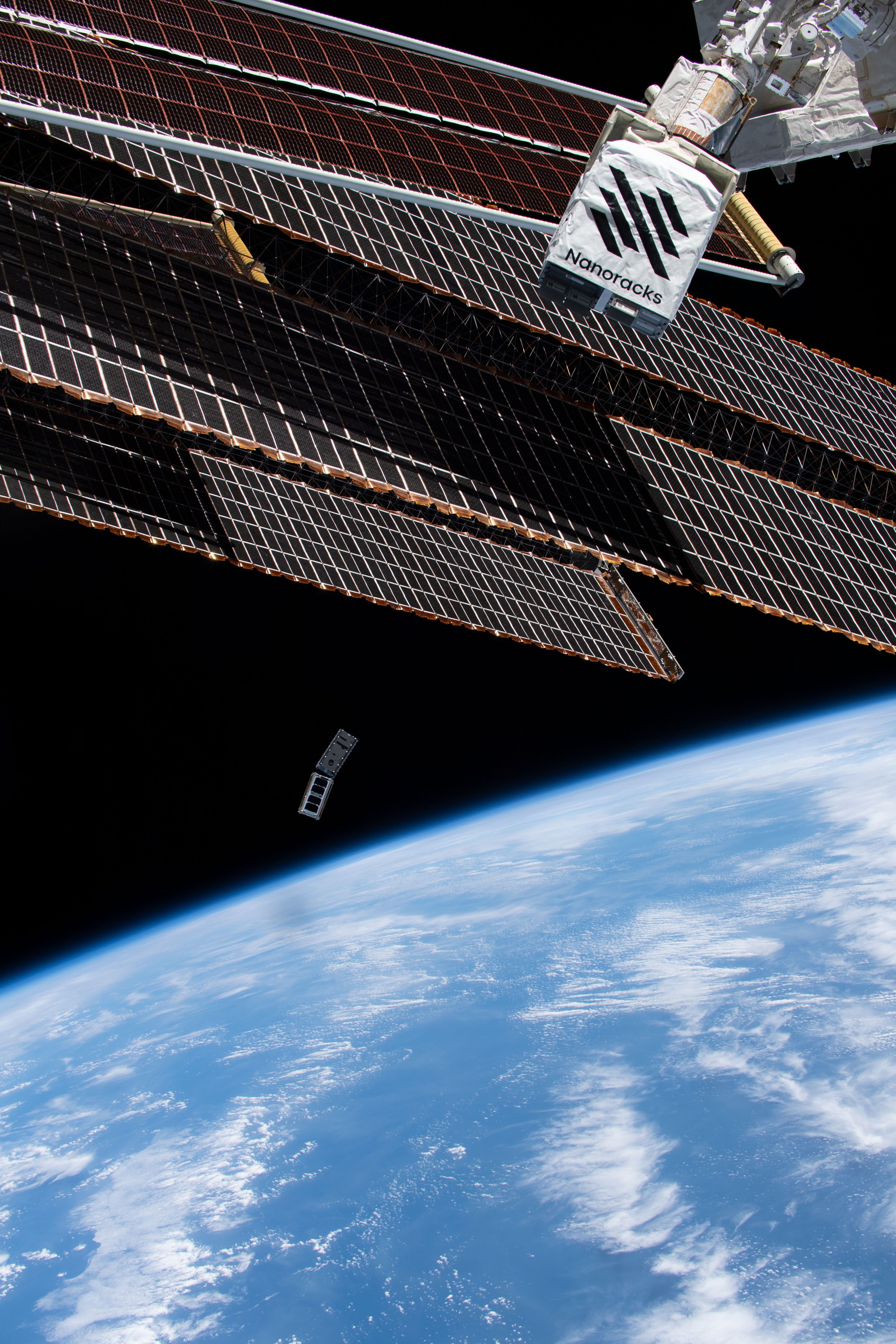 The ORCASat satellite being deployed into space, with Earth in the background