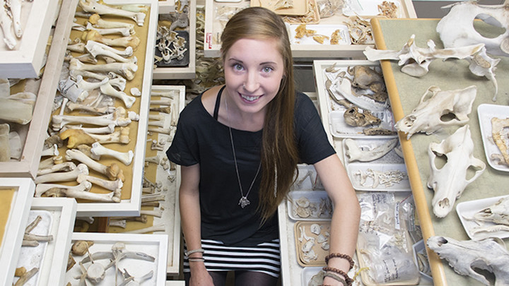 A female student sits with a bone collection