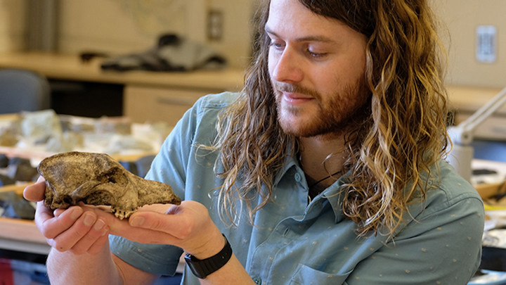 A male student holds an animal skeleton