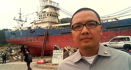 Santo Darmosumarto in front of a freight ship in Indonesia