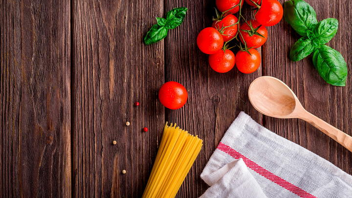 Ingredients for making spaghetti on a wooden table